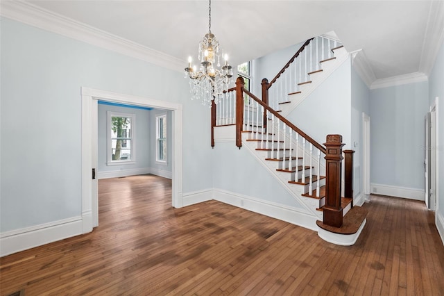 foyer featuring a notable chandelier, wood-type flooring, and ornamental molding