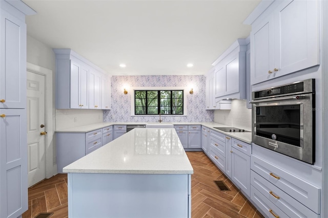 kitchen with stainless steel appliances, sink, light parquet flooring, and a center island