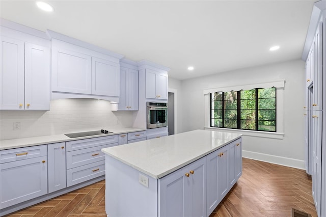 kitchen with oven, white cabinetry, black electric cooktop, a center island, and decorative backsplash