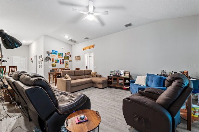 living room with ceiling fan, light hardwood / wood-style flooring, and vaulted ceiling