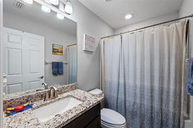 bathroom featuring vanity, toilet, a textured ceiling, and a shower with shower curtain