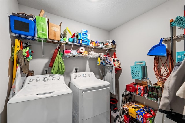 laundry area with a textured ceiling and washing machine and clothes dryer