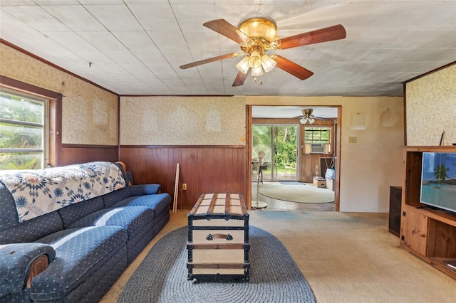 living room featuring a wealth of natural light, light colored carpet, and wood walls