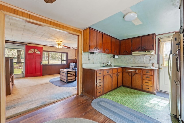 kitchen with decorative backsplash, ceiling fan, white gas stovetop, refrigerator, and light hardwood / wood-style floors