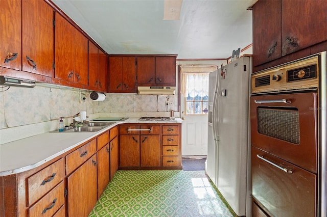 kitchen featuring ornamental molding, sink, white refrigerator with ice dispenser, and stainless steel gas cooktop