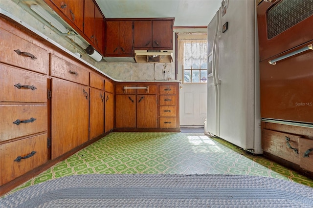 kitchen featuring white refrigerator with ice dispenser