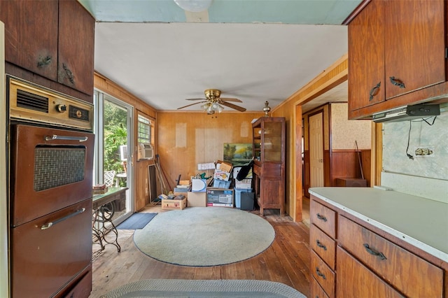 dining room featuring wooden walls, light hardwood / wood-style floors, and ceiling fan