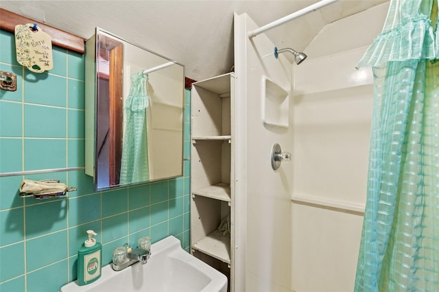 bathroom featuring decorative backsplash, walk in shower, sink, and tile walls