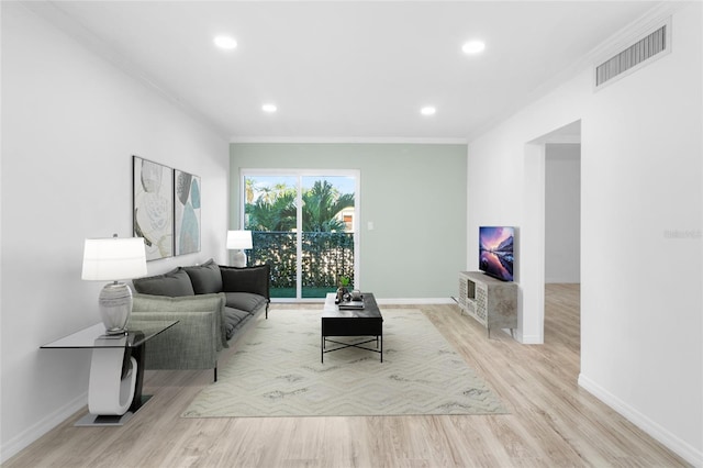 living room featuring ornamental molding and light hardwood / wood-style flooring