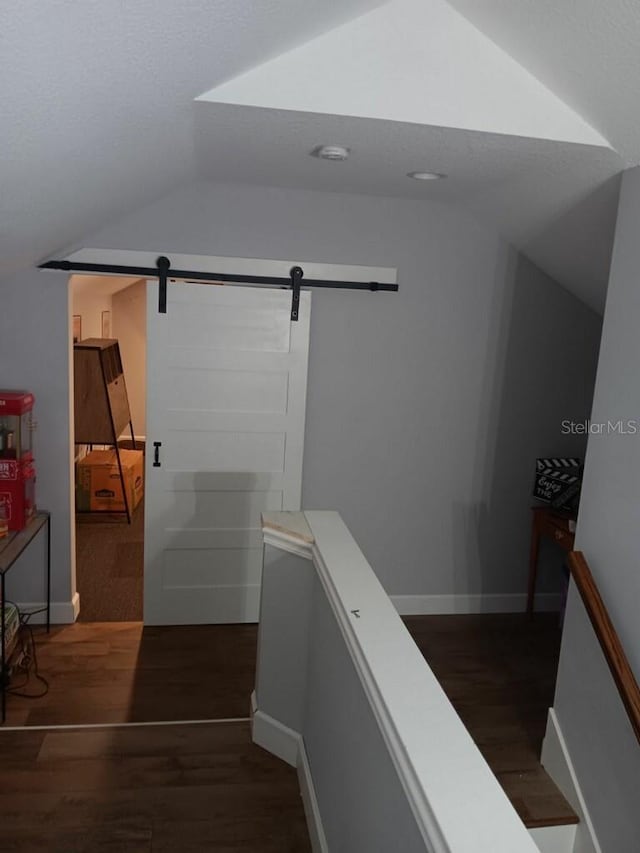 stairs with hardwood / wood-style flooring, lofted ceiling, and a barn door