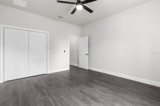 unfurnished bedroom featuring a textured ceiling, ceiling fan, a closet, and dark hardwood / wood-style floors