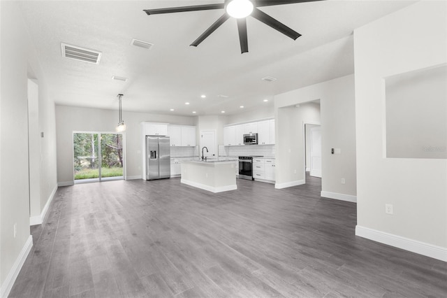 unfurnished living room featuring dark wood-type flooring, ceiling fan, and sink