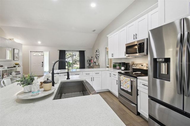 kitchen featuring white cabinets, lofted ceiling, sink, dark wood-type flooring, and appliances with stainless steel finishes