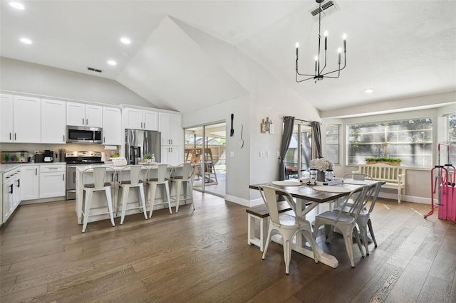 dining space featuring lofted ceiling, dark wood-type flooring, and a chandelier