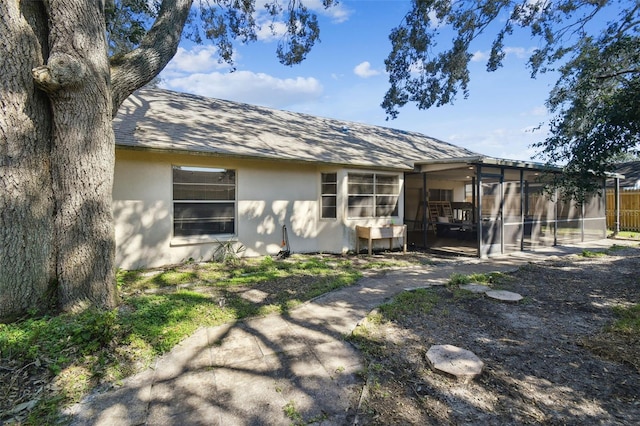 rear view of property featuring a sunroom