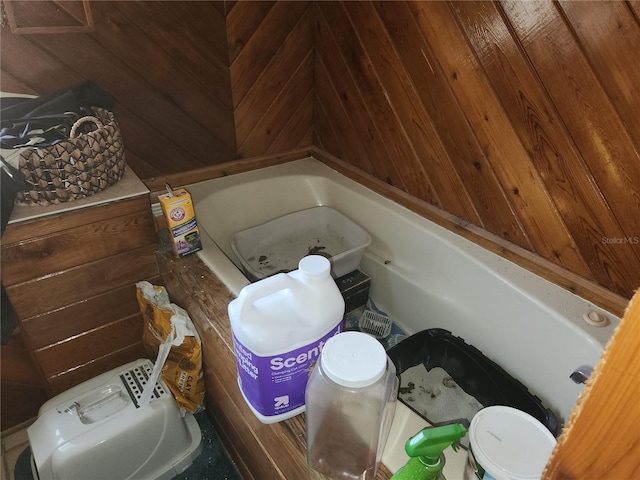 bathroom with a bathing tub and wooden walls