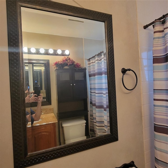 bathroom with vanity, toilet, and curtained shower