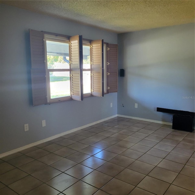 tiled spare room with a textured ceiling