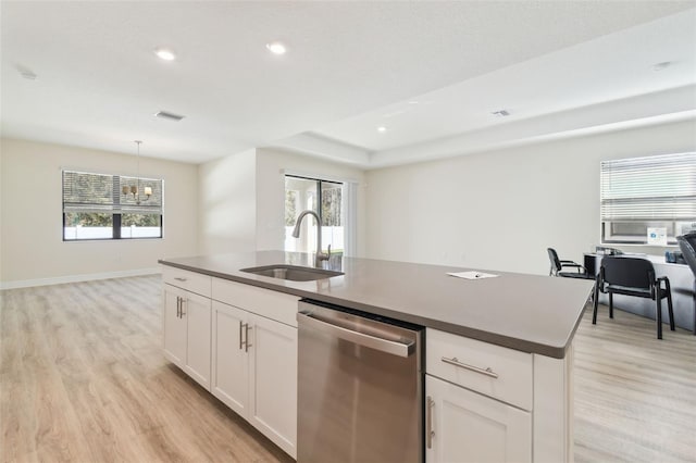 kitchen featuring a wealth of natural light, dishwasher, sink, white cabinets, and a center island with sink