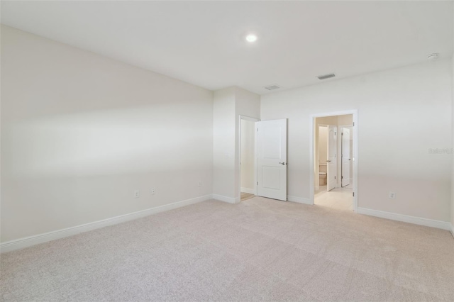 unfurnished bedroom featuring ensuite bath and light colored carpet