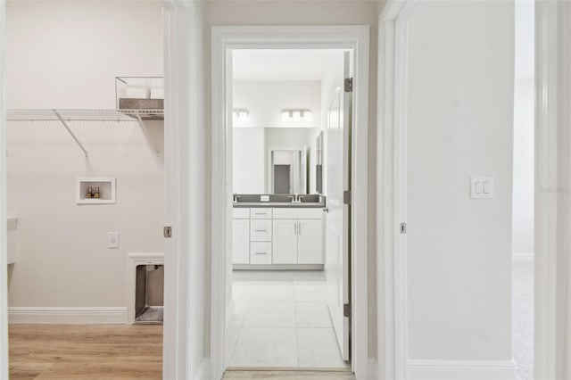 hallway featuring sink and light tile patterned floors