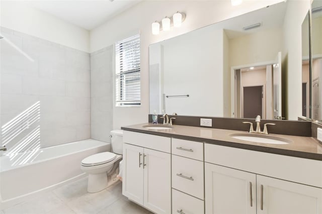 full bathroom featuring tiled shower / bath, vanity, toilet, and tile patterned flooring