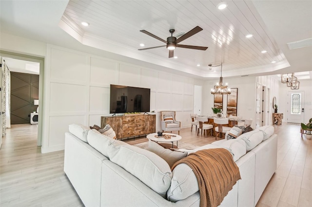 living room featuring ceiling fan with notable chandelier, light wood-type flooring, a tray ceiling, and wood ceiling