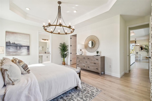 bedroom featuring a raised ceiling, light hardwood / wood-style flooring, crown molding, and ensuite bathroom