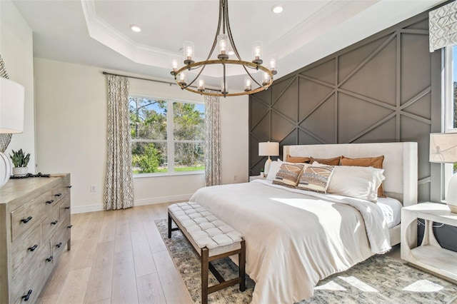 bedroom featuring light hardwood / wood-style flooring, crown molding, a raised ceiling, and a chandelier