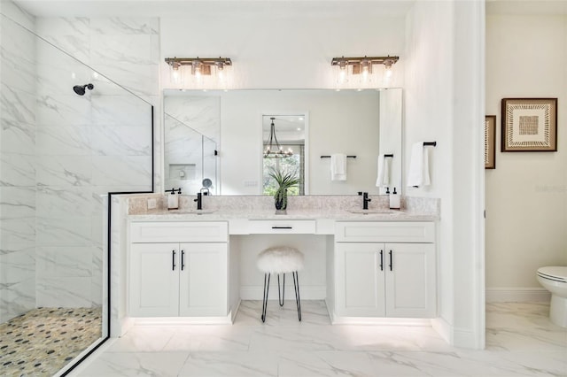 bathroom featuring a tile shower, vanity, toilet, and an inviting chandelier