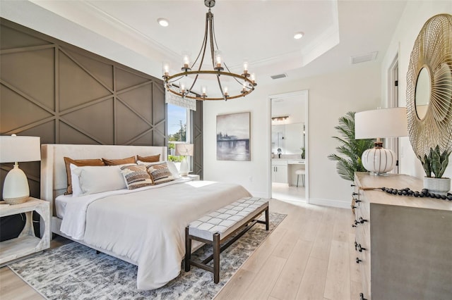 bedroom with ornamental molding, ensuite bath, and light hardwood / wood-style flooring