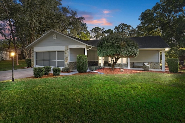 ranch-style home featuring covered porch and a lawn