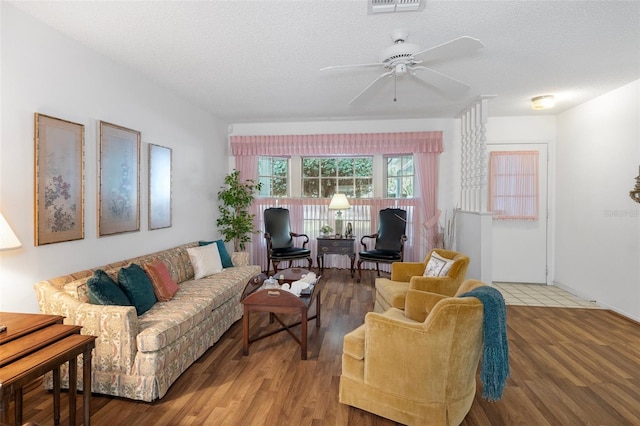 living room featuring a textured ceiling, wood-type flooring, and ceiling fan