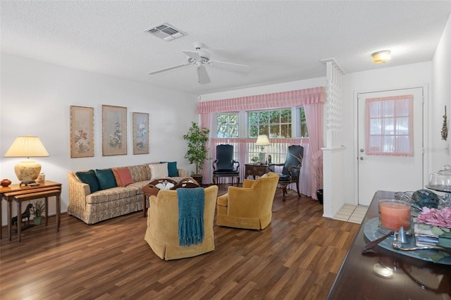 living room with dark hardwood / wood-style floors, a textured ceiling, and ceiling fan