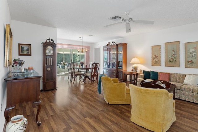 living room featuring a textured ceiling, dark hardwood / wood-style flooring, and ceiling fan with notable chandelier