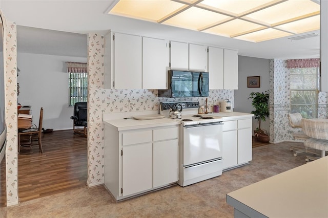 kitchen with white cabinetry, plenty of natural light, and white range with electric stovetop