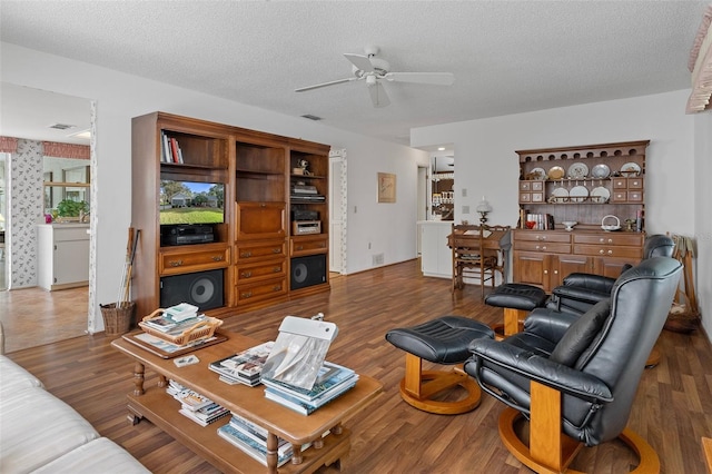 living room featuring a textured ceiling, ceiling fan, and dark hardwood / wood-style flooring