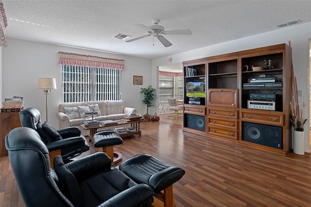 living room featuring ceiling fan, a textured ceiling, and dark hardwood / wood-style floors