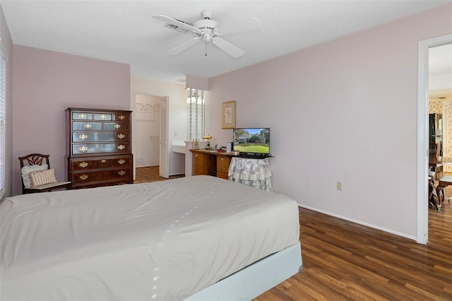 bedroom featuring ceiling fan, a textured ceiling, and dark hardwood / wood-style flooring