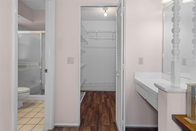 bathroom featuring vanity, toilet, an enclosed shower, and hardwood / wood-style floors