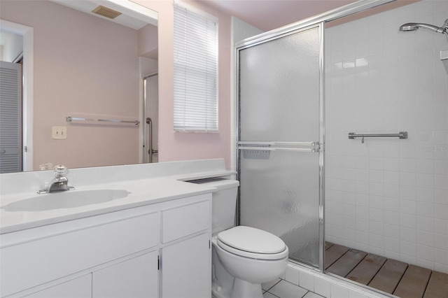 bathroom featuring vanity, toilet, tile patterned floors, and walk in shower