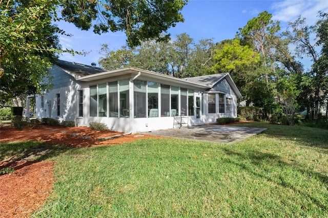 back of house with a patio, a sunroom, and a lawn