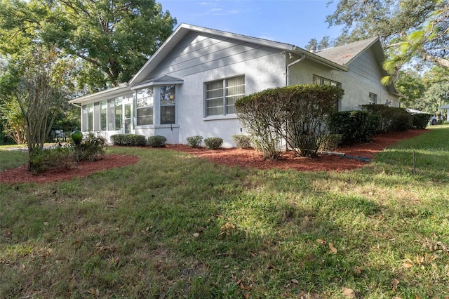 view of property exterior featuring a yard and a sunroom