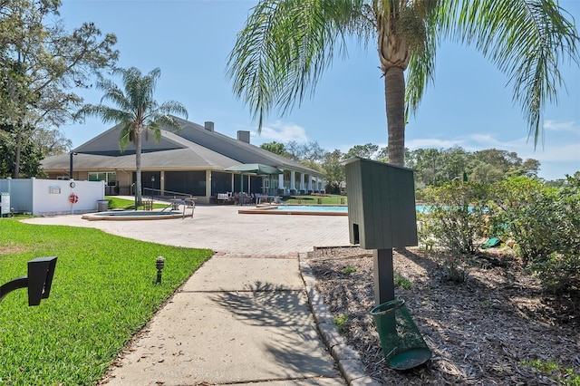 view of swimming pool featuring a yard and a patio