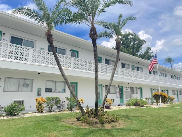 view of front of home with a front lawn and a balcony