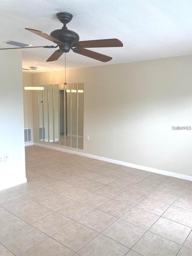 unfurnished room with light tile patterned flooring, a textured ceiling, and ceiling fan