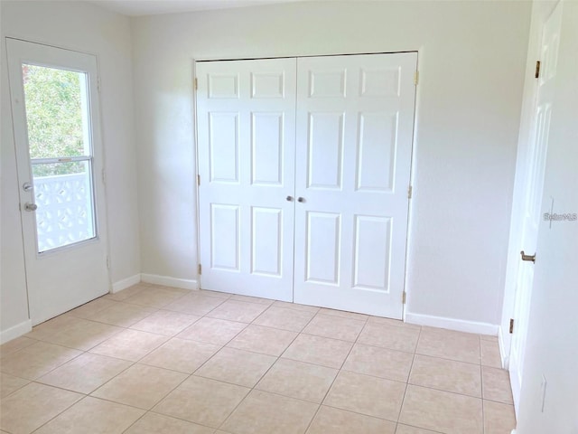 unfurnished bedroom with a closet and light tile patterned floors