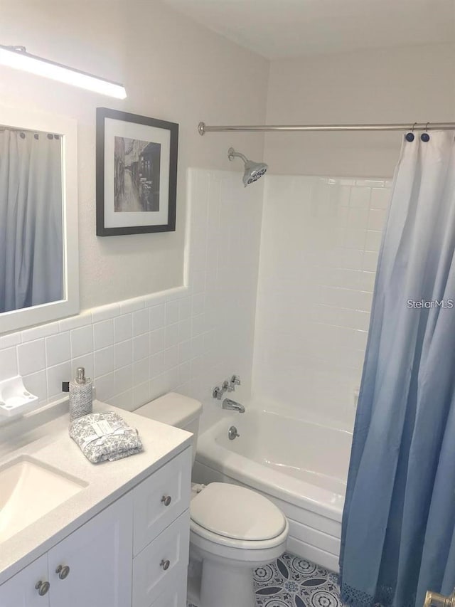 full bathroom with vanity, shower / bath combo, tile patterned floors, tile walls, and toilet