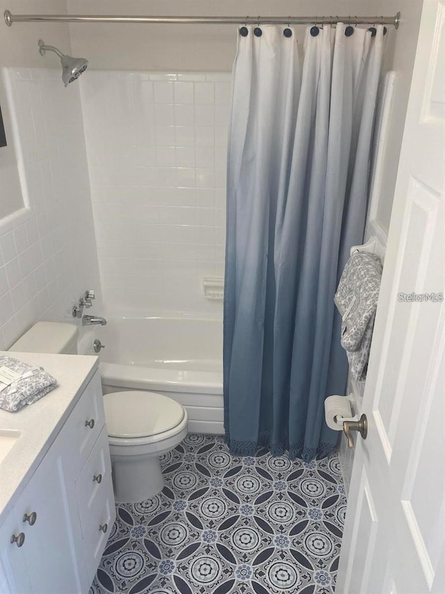 full bathroom featuring vanity, shower / bath combo with shower curtain, toilet, and tile patterned floors