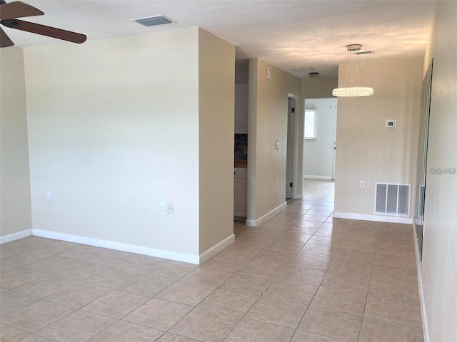 spare room featuring ceiling fan and light tile patterned floors